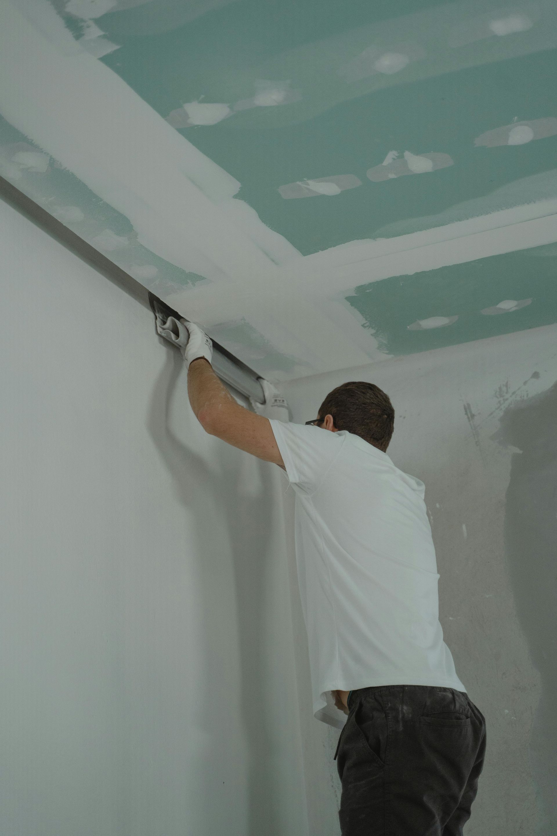 Worker finishing drywall
